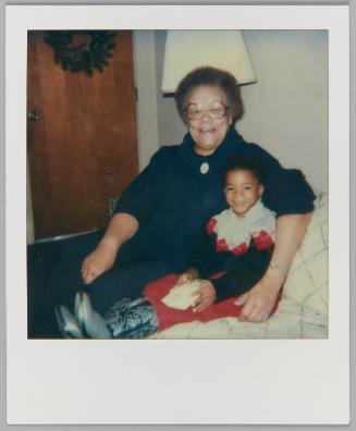 [Elderly woman sitting with little boy in cowboy boots]
