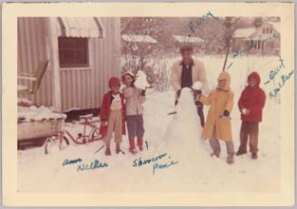 Ann Walker / Shannon Price / Perry / Bud Price / [illegible] Walker [Four children and man building snowman in front of home]
