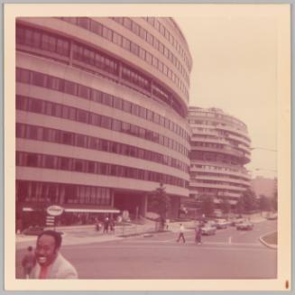 [Streetview of building with man smiling in bottom left corner]
