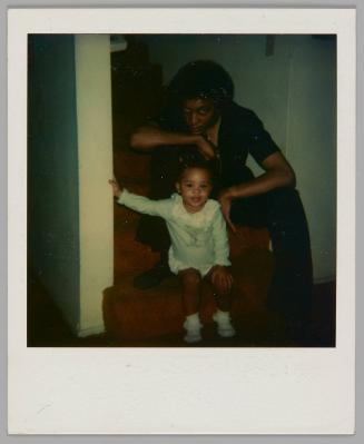 [Toddler sitting on stairs with man sitting behind them, he is resting his hand on his knee and his chin on his hand]