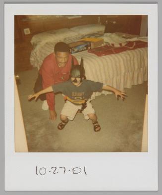 10.27.01 [Boy in Batman mask crouching with his arms spread wide, man in red sweatshirt kneeling behind him]