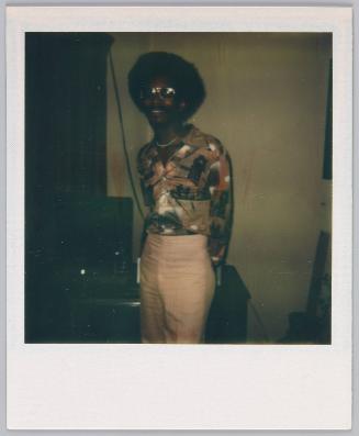 [Young man with afro, patterned shirt and khaki pants]