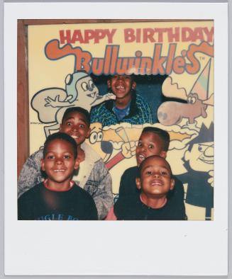 [Group of five little boys grinning, one stands behind "Happy Birthday Bullwinkle's" cutout]