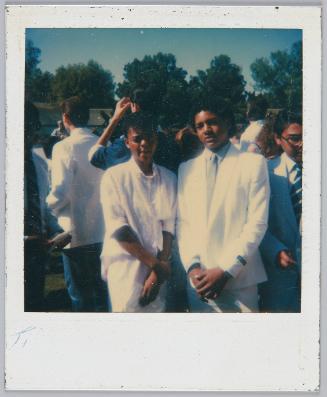 [Adolescent girl and boy posing in all whte outfits in a crowd]