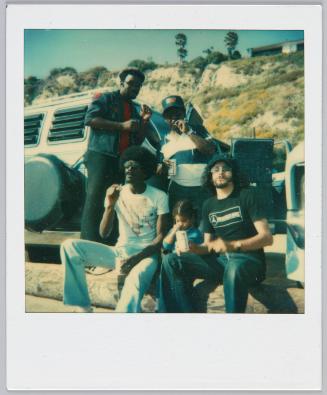 [Group of four men smoking cigarettes with little girl with pigtails sitting in between them]