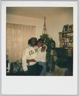 [Young couple with arms around each other, young man wears a Boston Celtics jacket]