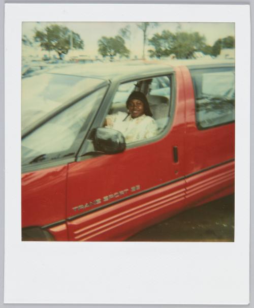 [Woman sitting in driver's seat of red Trans Sport SE]