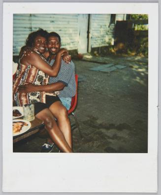 [Woman sitting on man's lap with her arms wrapped around him]