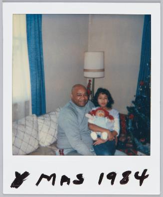 Xmas 1984 [Girl holding Cabbage Patch Kids doll sitting next to man in grey turtlneck on couch]