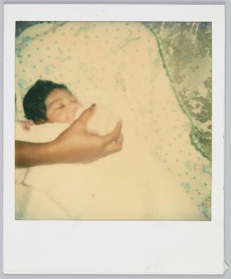 [Sleeping infant being bottle fed]