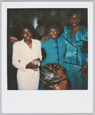 [Three women posing in formal outfits, woman on left in all light pink]