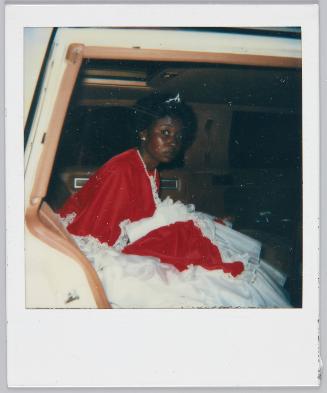 [Woman wearing tiara and red and white gown sitting in car]