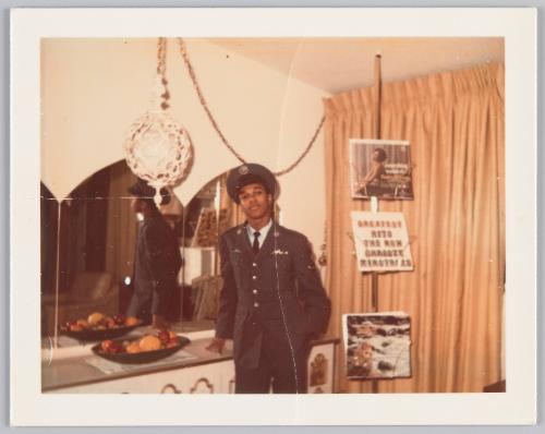 12-26-68 [Man in military uniform standing beside record rack, leaning on cabinet beside mirror]