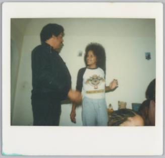 [Woman smiling at man to the left of her, one of her hands is raised at her hip]
