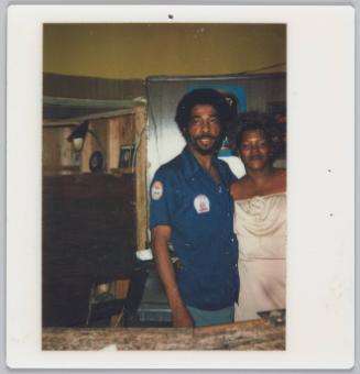 [Man and woman behind bar, woman is wearing a strapless white dress]
