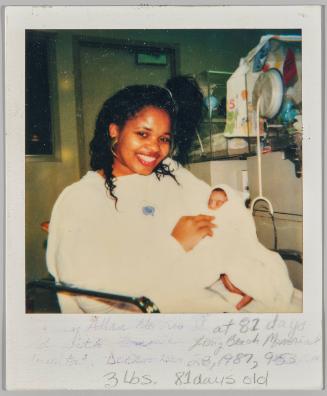 [illeg.] Allen Morris at 81 days old with [illeg.] Long Beach Memorial Hospital December 28, 1987, 9:53. 3 lbs. 81 days old [Woman sitting in a hosptial room and holding small baby wrapped in a blanket]