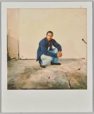 Jan 1, 1993 [Man crouched down outside in front of white wall with his hands together]