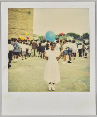 [Girl in white dress with blue balloon, standing outside with more children behind her]