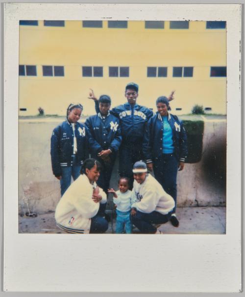 [Seven people outside, three women wearing "NY" jackets and man in "Cowboys" jacket]