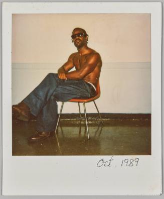 Oct 1989 [Shirtless man wearing sunglasses sitting on chair with legs crossed]