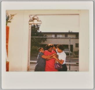 [Three women hugging and rough-housing outside doorway]
