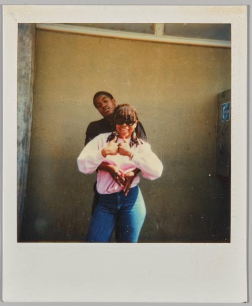 [Young couple posing, woman holding two thumbs up]
