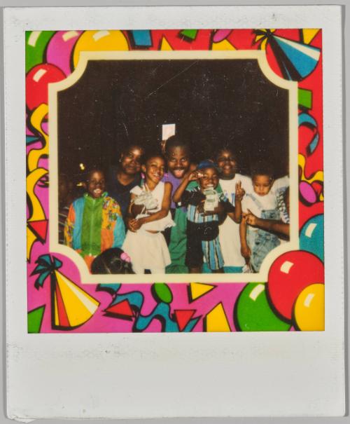 [Three adults with four children posing as group with birthday themed border]
