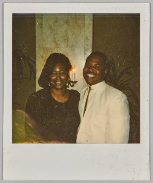 [Man and woman smiling together with candle light fixture in the background]
