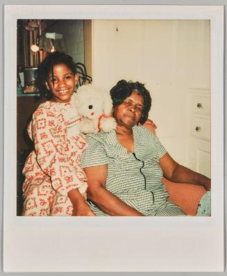 [little girl posing with older woman and plush dog]

