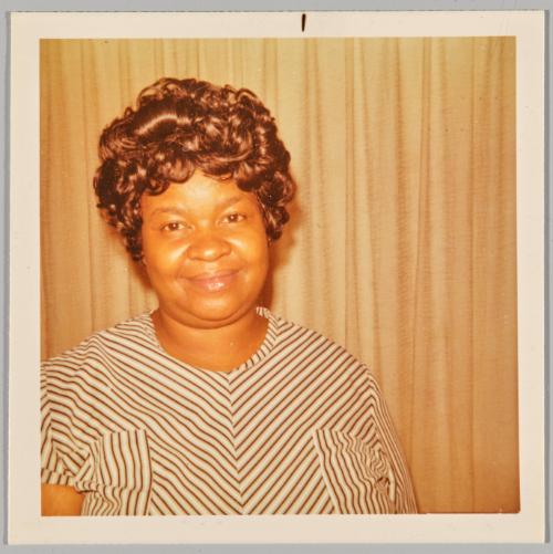 [Portrait of woman in a striped top and short brown hair]
