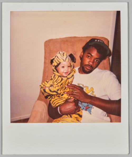 10/31/90 [Man holding toddler in tiger costume]