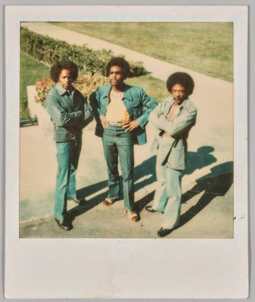 [Three men in denim and afros posing]
