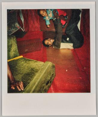 [Man laying on ground with legs in air holding baby above him]
