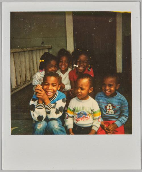 [Three girls and three boys sitting together and smiling on porch]
