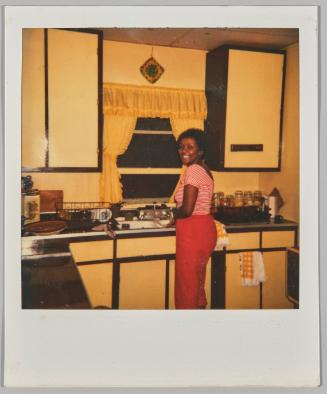 Pat - July 4, 1981 [Woman smiling washing dishes in kitchen sink]