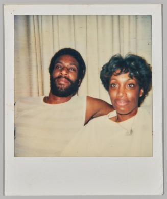 [Man and woman in white in front of white curtains]
