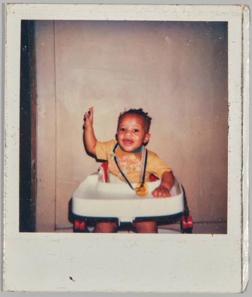 [Baby in highchair with soother fastened around neck]
