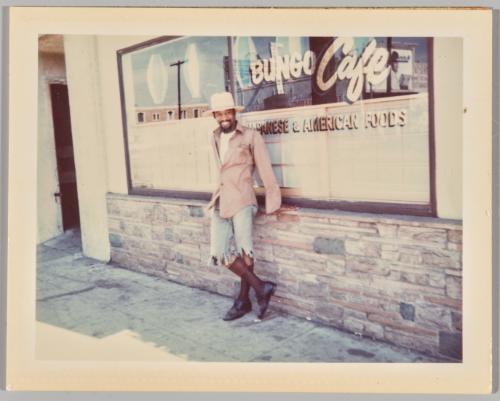 [Man posing in front of Bungo Café]
