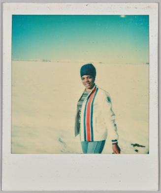[Woman in knitted hat standing in snowy field]
