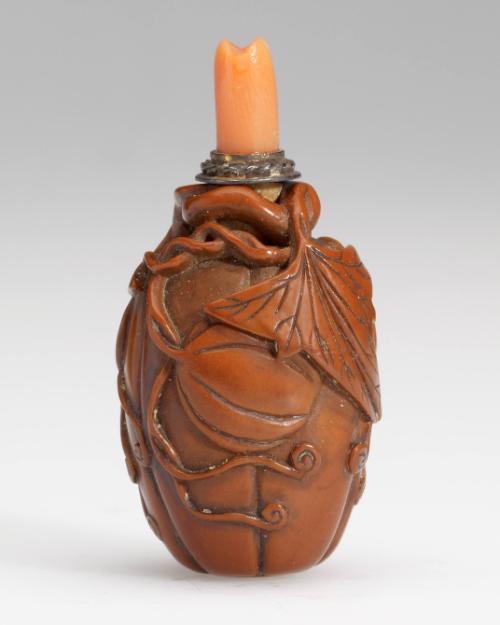 Lobed melon carved fruitstone snuff bottle with a coral stopper