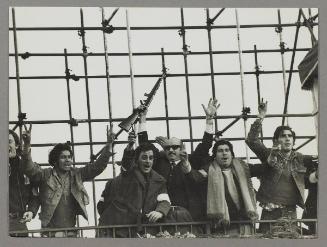 [Right-wing Peronists, including Pedro Antonio Mento in the sunglasses, armed and celebrating their victory against the left wing factions of Peronism on the tribune from which Perón was due to deliver his speech]
