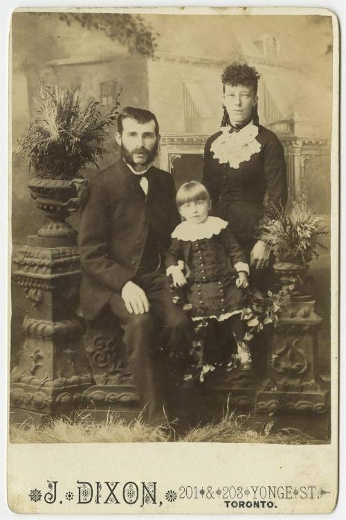 [Family portrait with seated child]