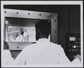 A model takes position in the medical facility room directly beneath the core of the new Massachusetts Institute of Technology nuclear reactor in Cambridge, The opening above her head admits radiation controlled by the operator outside the room