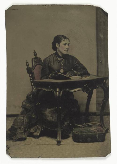 Seated woman at table, wearing gloves