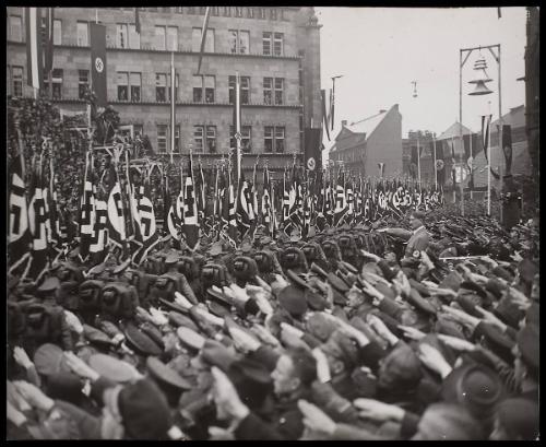 Hitler saluting marching troops.