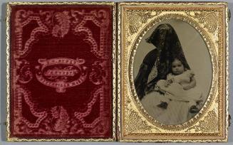 Portrait of young girl (seated in lap of shrouded figure)