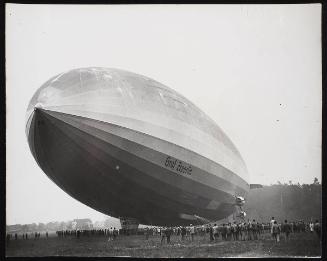 Nazi 'Graf' zeppelin with crowd of people underneath it.