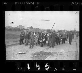 Large group of residents and policemen carrying belongings during deportation from the Lodz Ghetto
