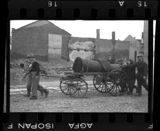 Fecal workers hauling a sewage collecting tank mounted on a wagon through the ghetto
