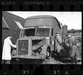 Officials inspecting cars after liberation